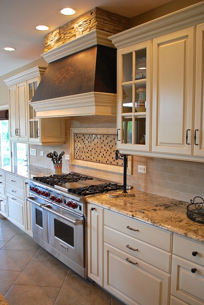 Example of a large transitional u-shaped ceramic tile eat-in kitchen design in Chicago with a farmhouse sink, recessed-panel cabinets, white cabinets, granite countertops, beige backsplash, subway tile backsplash, stainless steel appliances and an island