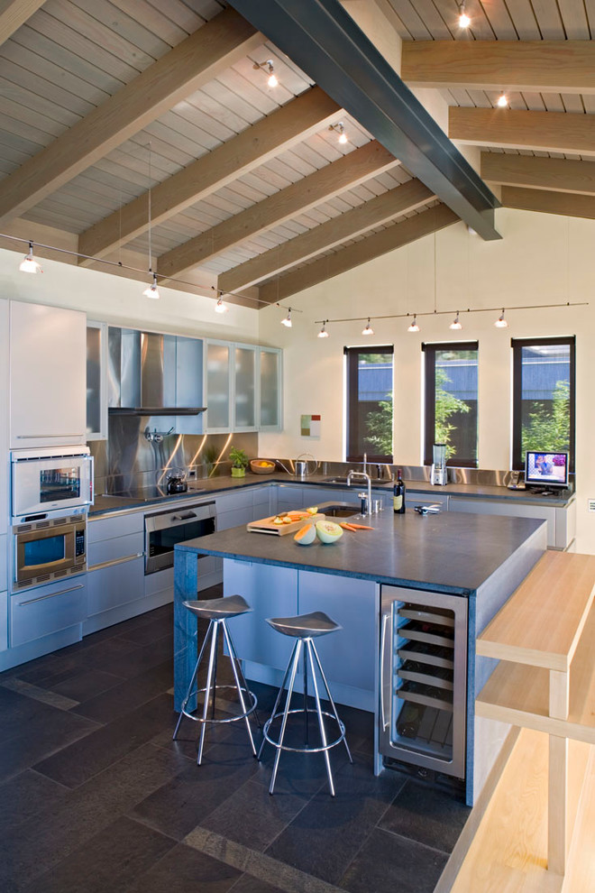 サンディエゴにあるコンテンポラリースタイルのおしゃれなキッチン (アンダーカウンターシンク、フラットパネル扉のキャビネット、白いキャビネット、ステンレスのキッチンパネル) の写真