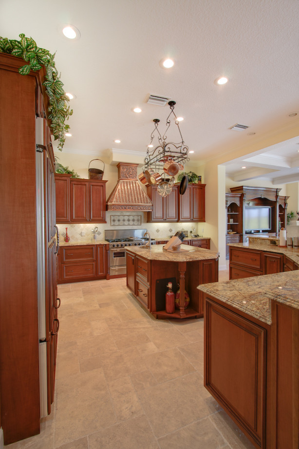 Zweizeilige Moderne Küche mit Einbauwaschbecken, profilierten Schrankfronten, hellbraunen Holzschränken, Granit-Arbeitsplatte, Küchenrückwand in Beige, Keramikboden und Kücheninsel in Tampa