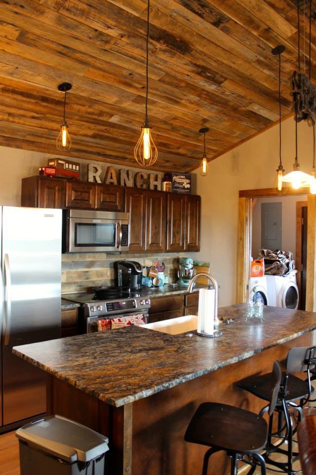 Mittelgroße, Einzeilige Rustikale Küche mit Landhausspüle, profilierten Schrankfronten, dunklen Holzschränken, Granit-Arbeitsplatte, Küchengeräten aus Edelstahl und Kücheninsel in Austin