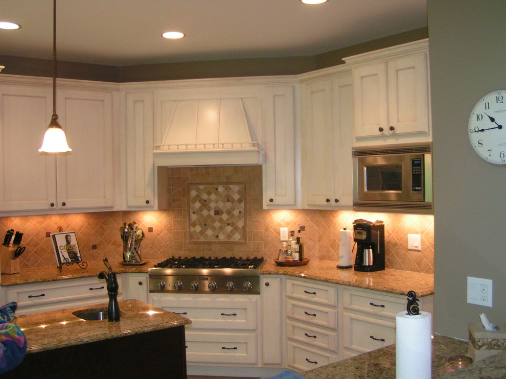 Exempel på ett klassiskt kök och matrum, med luckor med infälld panel, vita skåp, granitbänkskiva, beige stänkskydd, stänkskydd i porslinskakel och rostfria vitvaror