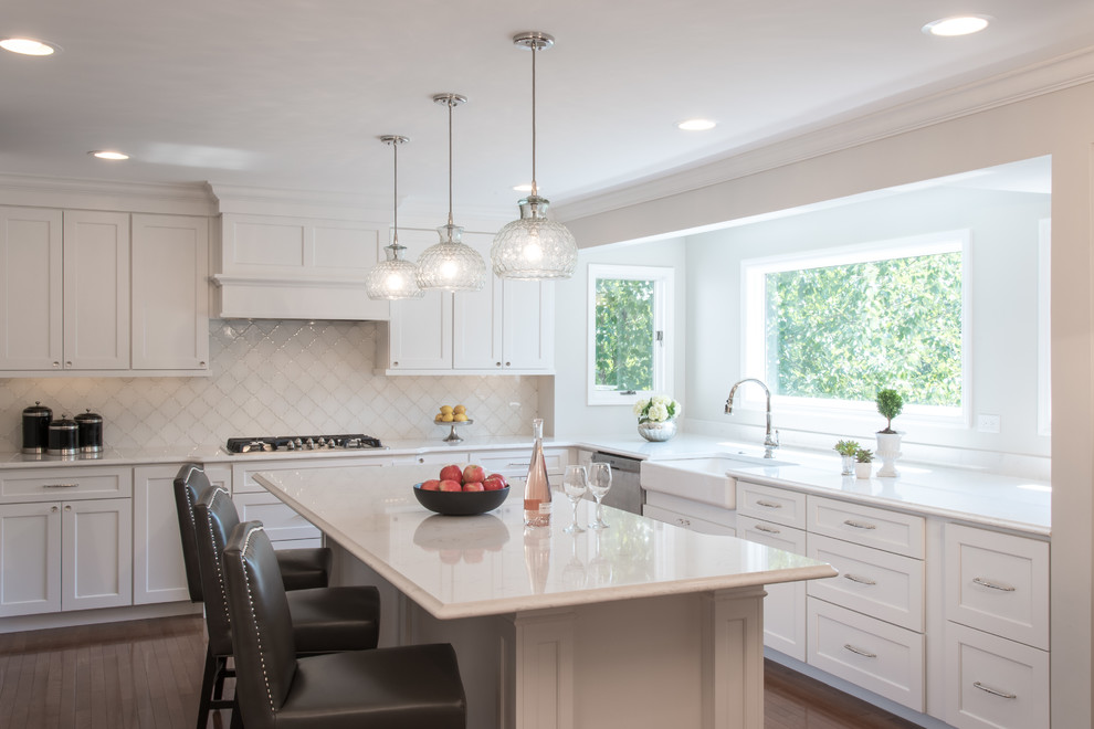 Klassische Küche in L-Form mit Landhausspüle, Schrankfronten im Shaker-Stil, weißen Schränken, Küchenrückwand in Weiß, dunklem Holzboden und Kücheninsel in St. Louis