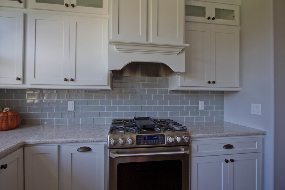 Moderne Küche mit Küchenrückwand in Grau, Rückwand aus Glasfliesen und Küchengeräten aus Edelstahl in Sonstige