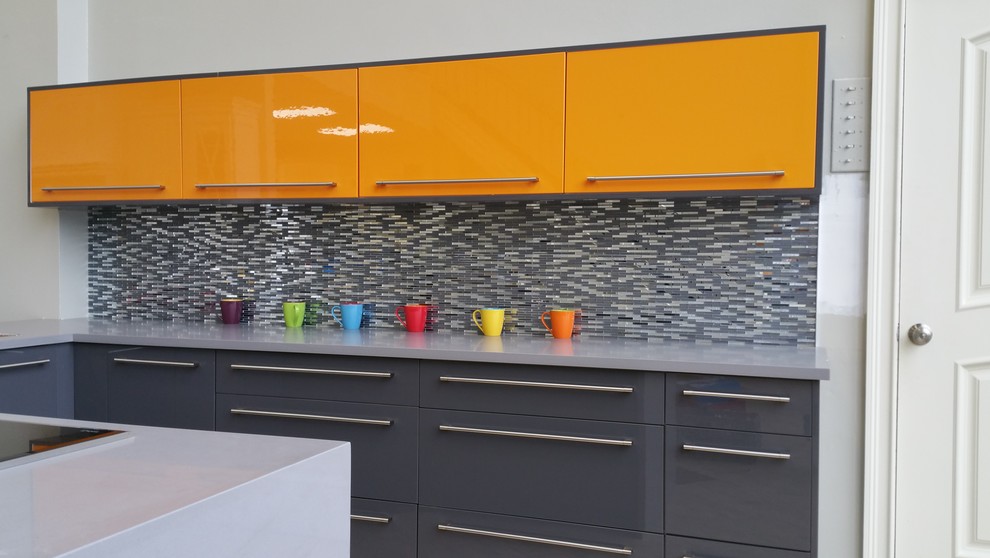 Immagine di una cucina ad U moderna chiusa e di medie dimensioni con lavello sottopiano, ante lisce, ante arancioni, top in quarzo composito, paraspruzzi grigio, paraspruzzi con piastrelle di vetro, pavimento con piastrelle in ceramica e penisola