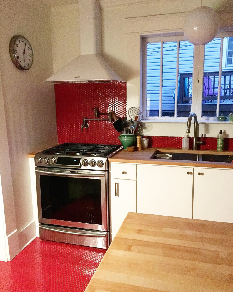 Immagine di un cucina con isola centrale moderno con ante lisce, ante bianche, top in legno, paraspruzzi con piastrelle a mosaico, elettrodomestici in acciaio inossidabile e paraspruzzi rosso