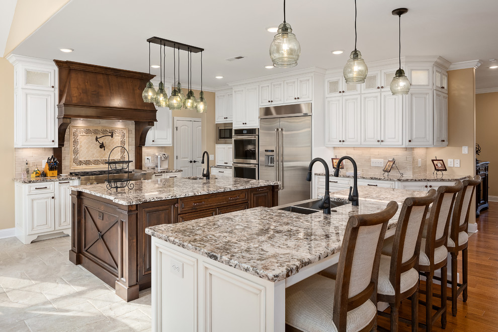 Classic grey and cream l-shaped kitchen in Nashville with a submerged sink, raised-panel cabinets, white cabinets, beige splashback, stainless steel appliances, multiple islands, beige floors and beige worktops.