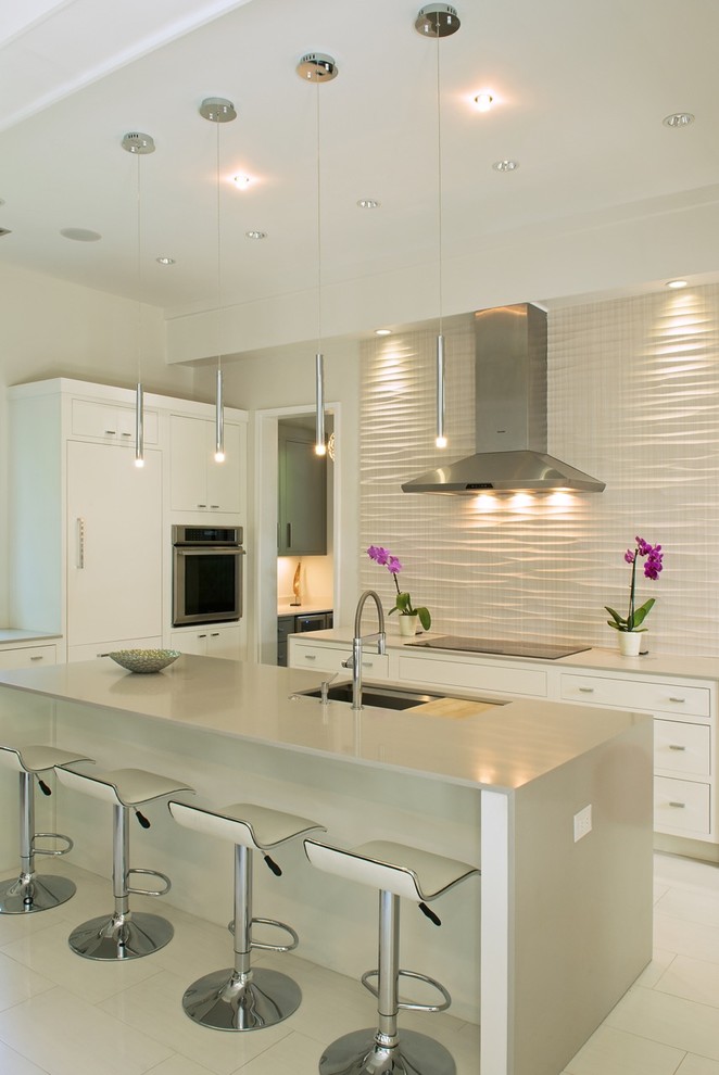 Moderne Küche in U-Form mit Unterbauwaschbecken, weißen Schränken und Kücheninsel in Charleston