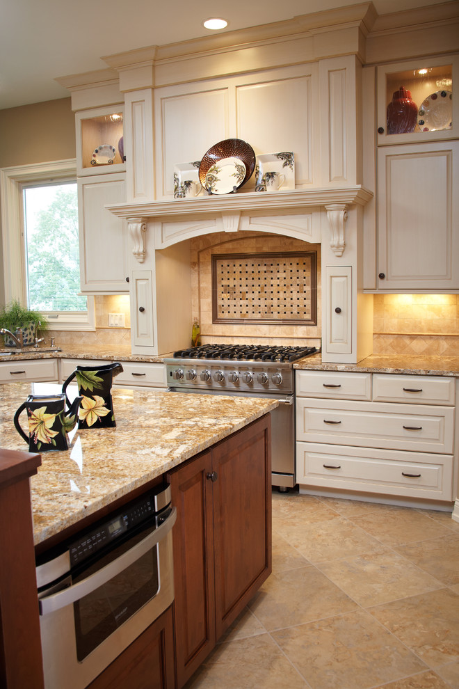 Foto di una cucina classica con top in granito, paraspruzzi beige, paraspruzzi con piastrelle in pietra, elettrodomestici in acciaio inossidabile e pavimento in gres porcellanato
