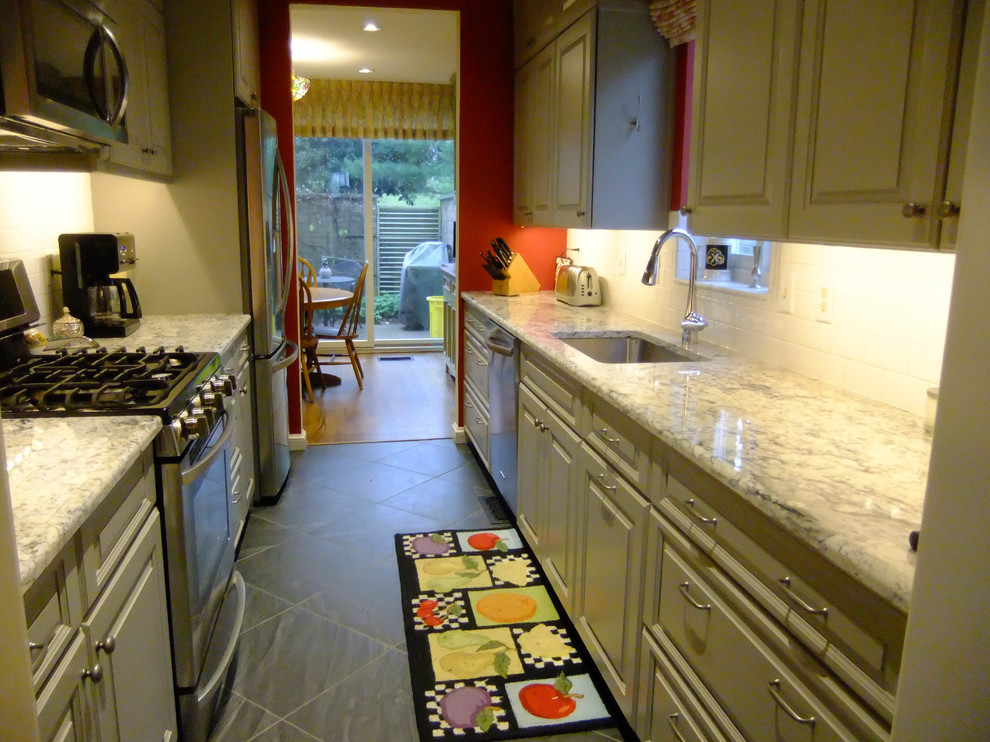 This is an example of a large rural galley kitchen/diner in Baltimore with a single-bowl sink, recessed-panel cabinets, green cabinets, wood worktops, stainless steel appliances, white splashback, metro tiled splashback, cement flooring, no island and grey floors.