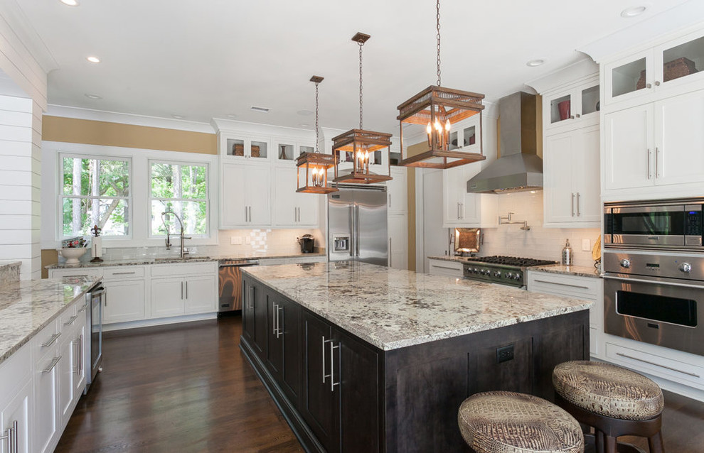 Large transitional u-shaped brown floor and dark wood floor enclosed kitchen photo in Charleston with shaker cabinets, granite countertops, stainless steel appliances, an undermount sink, white cabinets, white backsplash, subway tile backsplash, an island and multicolored countertops