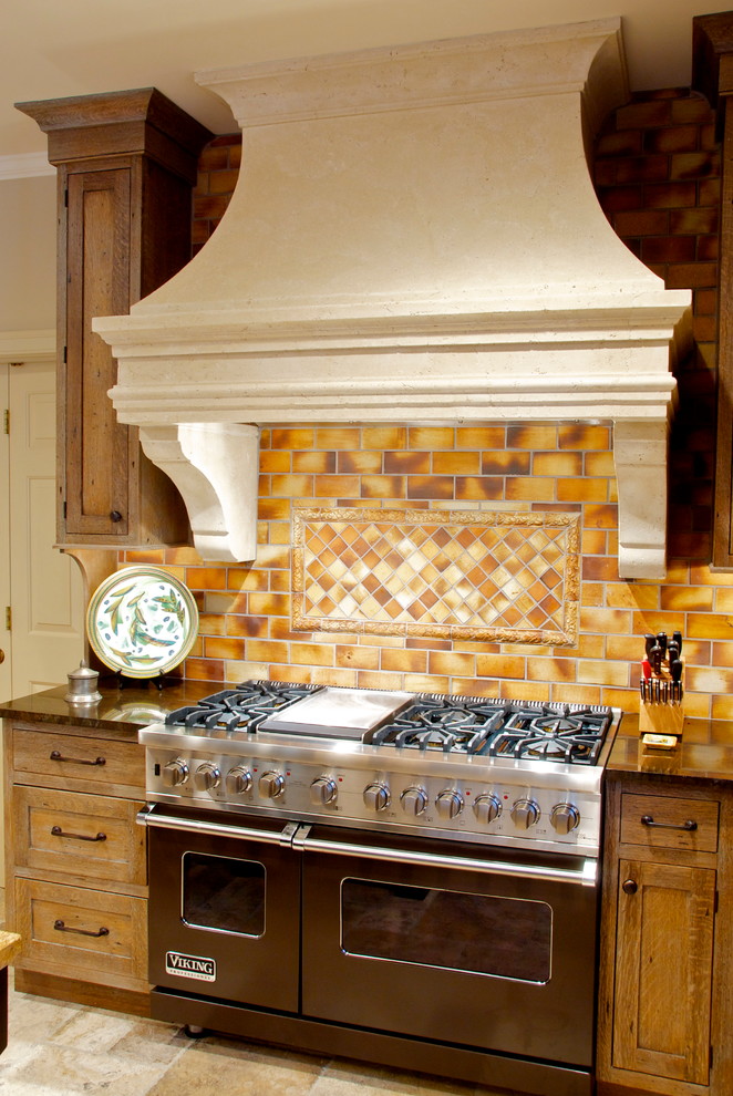 Imagen de cocina rural con fregadero sobremueble, armarios con paneles empotrados, puertas de armario con efecto envejecido y salpicadero naranja