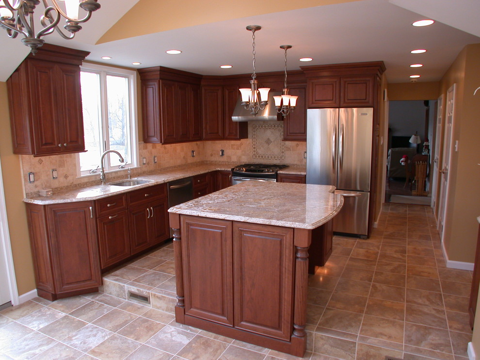 Exempel på ett mellanstort klassiskt kök, med en enkel diskho, luckor med upphöjd panel, skåp i mellenmörkt trä, granitbänkskiva, beige stänkskydd, stänkskydd i stenkakel, rostfria vitvaror, klinkergolv i porslin och en köksö