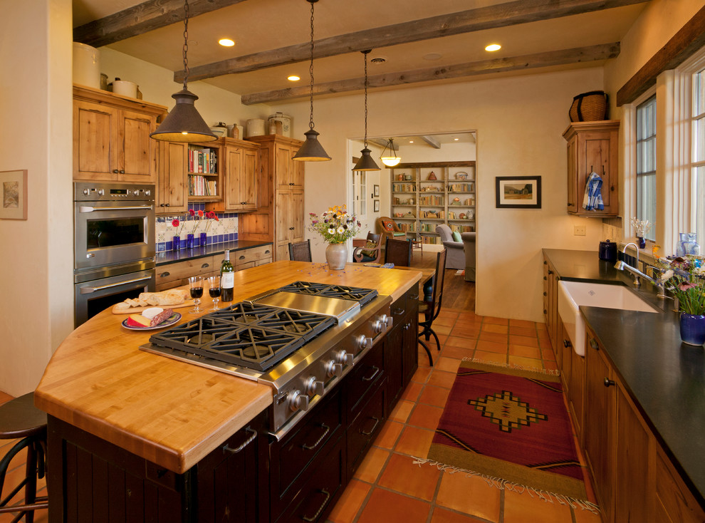 Exempel på ett mellanstort amerikanskt kök, med en rustik diskho, skåp i shakerstil, träbänkskiva, flerfärgad stänkskydd, stänkskydd i keramik, rostfria vitvaror, klinkergolv i terrakotta, en köksö och skåp i mörkt trä