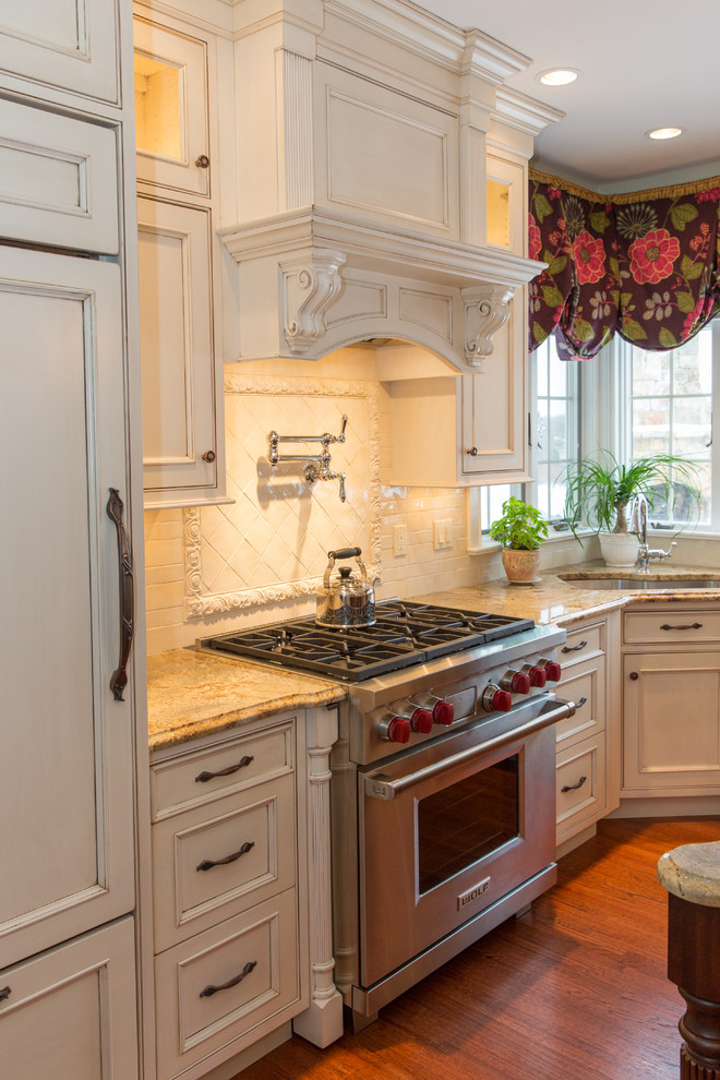 Exempel på ett mellanstort klassiskt kök och matrum, med en trippel diskho, luckor med profilerade fronter, granitbänkskiva, beige stänkskydd, stänkskydd i keramik och integrerade vitvaror