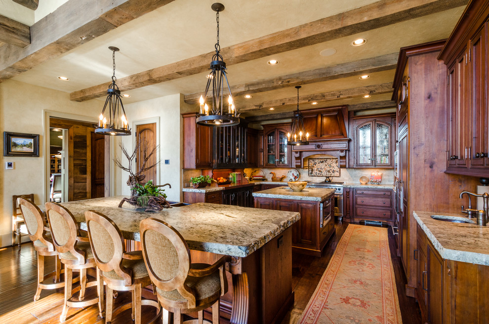 Elegant u-shaped eat-in kitchen photo in Atlanta with an undermount sink, raised-panel cabinets, dark wood cabinets, granite countertops, beige backsplash and paneled appliances