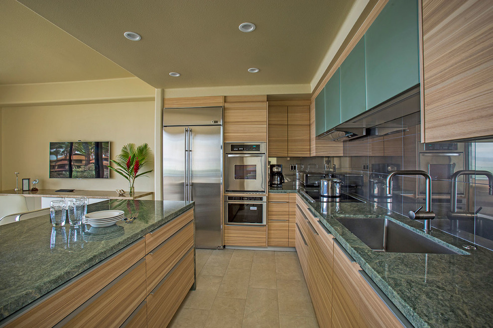 ハワイにあるコンテンポラリースタイルのおしゃれなキッチン (アンダーカウンターシンク、フラットパネル扉のキャビネット、中間色木目調キャビネット、シルバーの調理設備、緑のキッチンカウンター) の写真