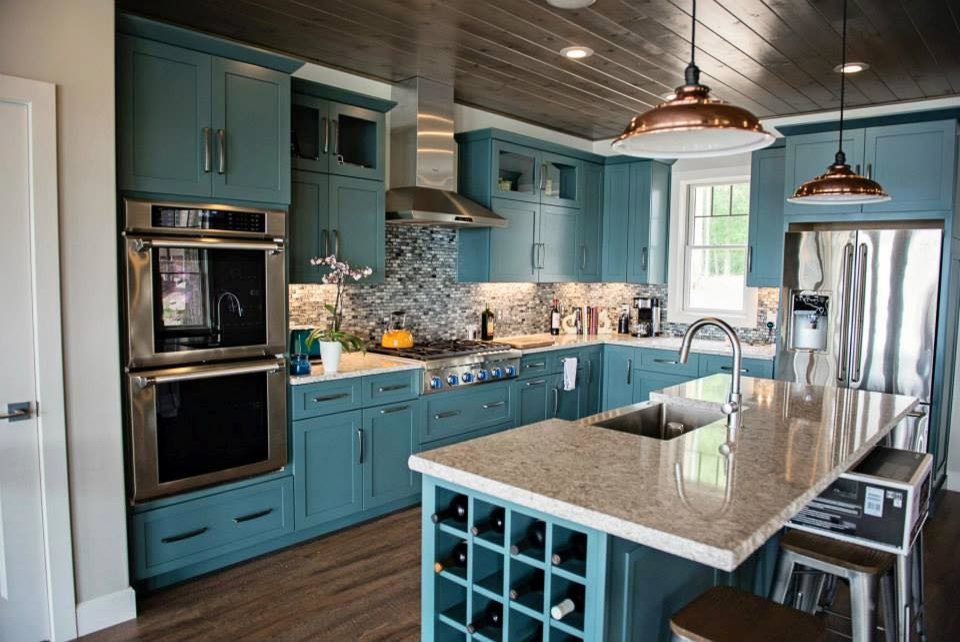 Пример оригинального дизайна: кухня в стиле шебби-шик с врезной мойкой, синими фасадами, гранитной столешницей, разноцветным фартуком, фартуком из стеклянной плитки, техникой из нержавеющей стали, островом и полом из винила