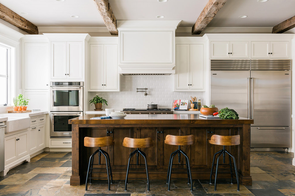Example of a farmhouse kitchen design in Atlanta with a farmhouse sink, recessed-panel cabinets and an island