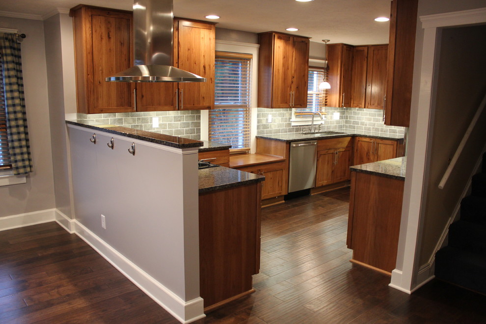 Inredning av ett modernt mellanstort u-kök, med en undermonterad diskho, skåp i shakerstil, skåp i mellenmörkt trä, grått stänkskydd, rostfria vitvaror, mellanmörkt trägolv och brunt golv