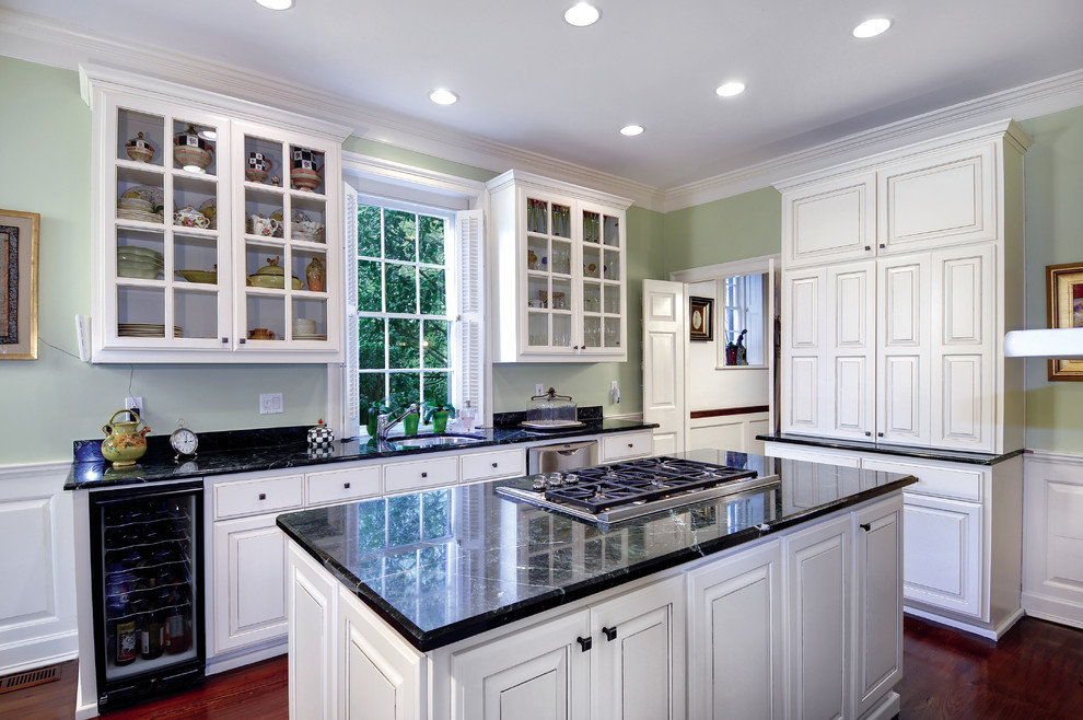 Imagen de cocina clásica con fregadero bajoencimera, armarios con paneles con relieve, puertas de armario blancas y electrodomésticos de acero inoxidable