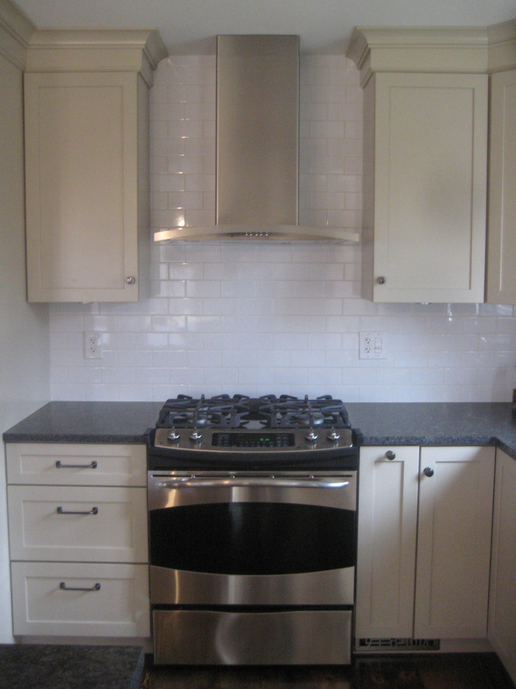 Foto på ett mellanstort rustikt kök, med en rustik diskho, skåp i shakerstil, vita skåp, granitbänkskiva, vitt stänkskydd, stänkskydd i tunnelbanekakel, rostfria vitvaror, mörkt trägolv och en köksö