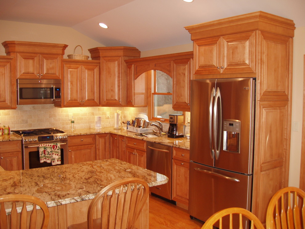 Exempel på ett stort modernt kök, med en undermonterad diskho, luckor med upphöjd panel, skåp i mellenmörkt trä, granitbänkskiva, beige stänkskydd, stänkskydd i keramik, rostfria vitvaror, mellanmörkt trägolv, en halv köksö och beiget golv