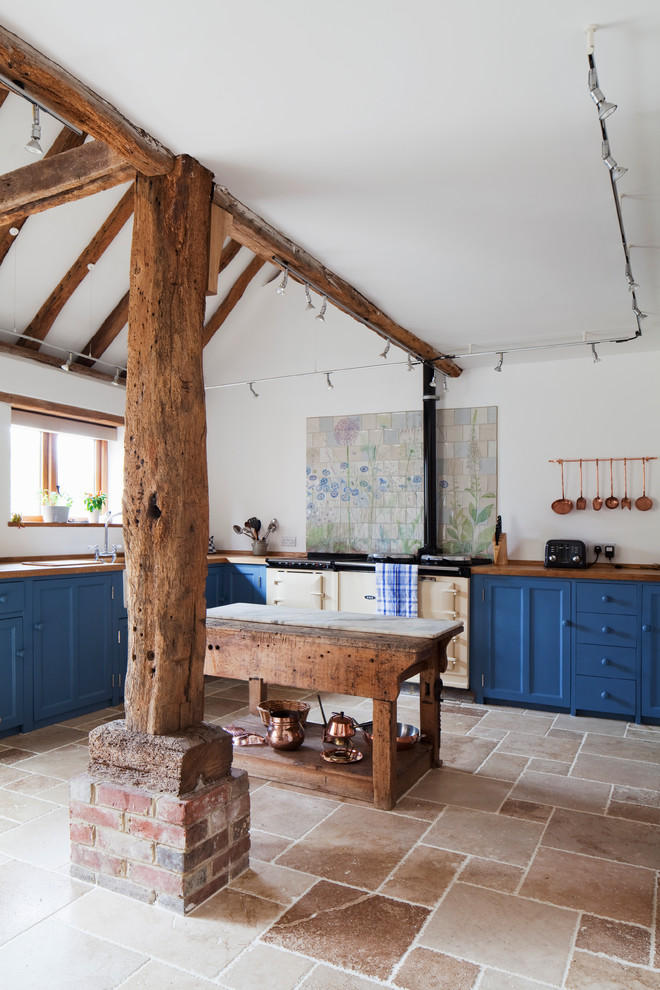 Landhausstil Wohnküche in L-Form mit Landhausspüle, blauen Schränken, Arbeitsplatte aus Holz, Schrankfronten im Shaker-Stil, bunten Elektrogeräten und Kücheninsel in Sussex