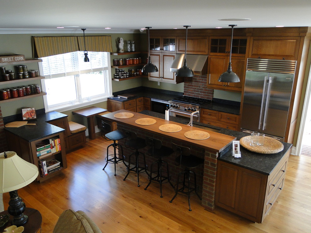 ボストンにある高級な中くらいなトラディショナルスタイルのおしゃれなキッチン (アンダーカウンターシンク、レイズドパネル扉のキャビネット、中間色木目調キャビネット、シルバーの調理設備、淡色無垢フローリング) の写真