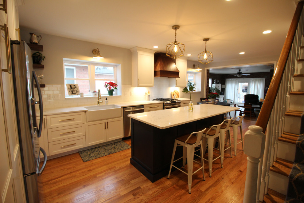 Bild på ett mellanstort vintage vit linjärt vitt kök och matrum, med en rustik diskho, skåp i shakerstil, blå skåp, bänkskiva i kvartsit, vitt stänkskydd, stänkskydd i tunnelbanekakel, rostfria vitvaror, mellanmörkt trägolv och en köksö