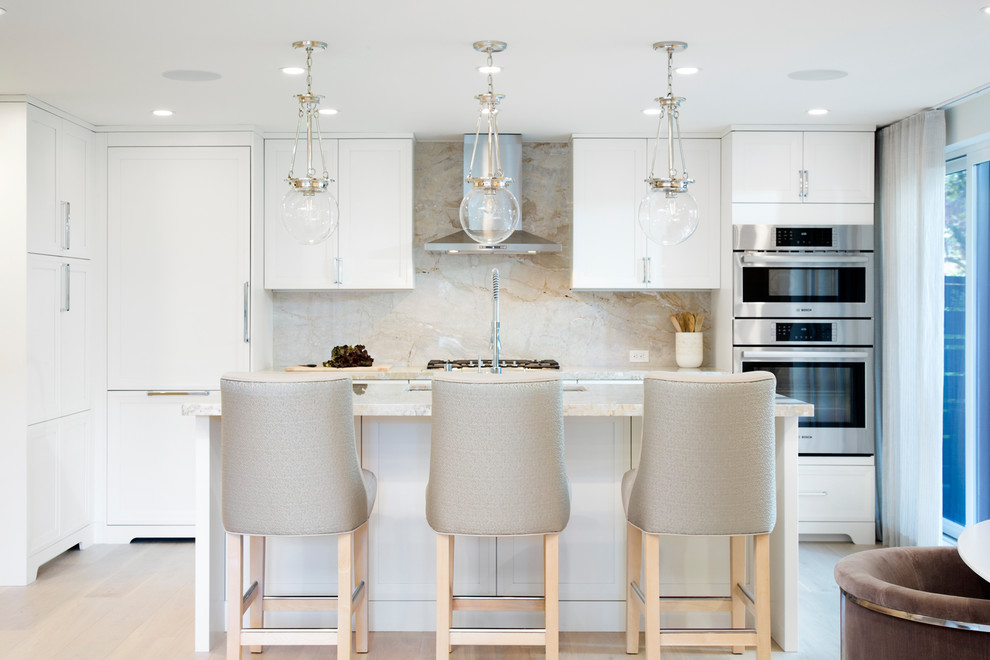Mid-sized transitional galley light wood floor and beige floor eat-in kitchen photo in Vancouver with an undermount sink, white cabinets, marble countertops, marble backsplash, paneled appliances, an island, recessed-panel cabinets and beige backsplash