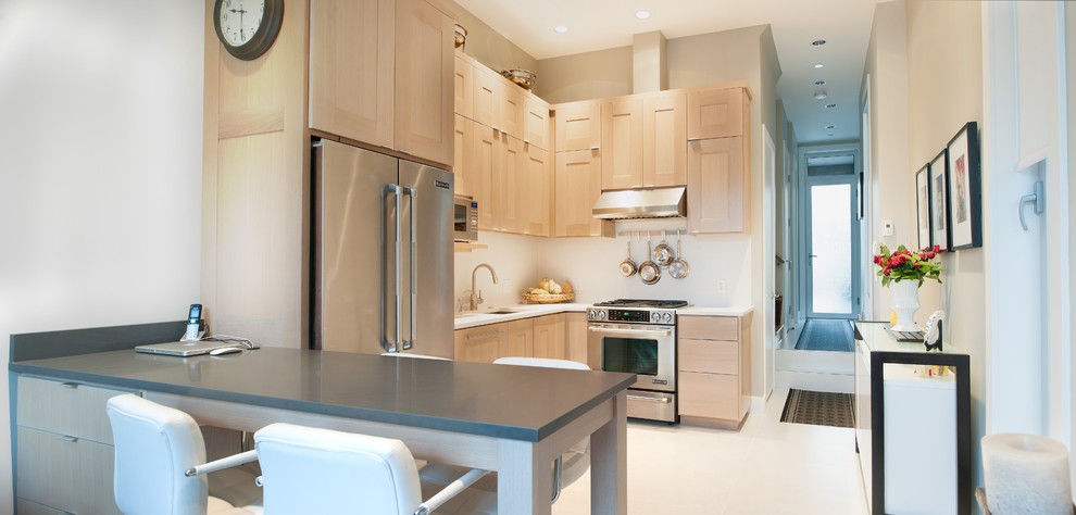 Diseño de cocina contemporánea con fregadero bajoencimera, puertas de armario de madera clara, encimera de cuarzo compacto, salpicadero blanco y electrodomésticos de acero inoxidable