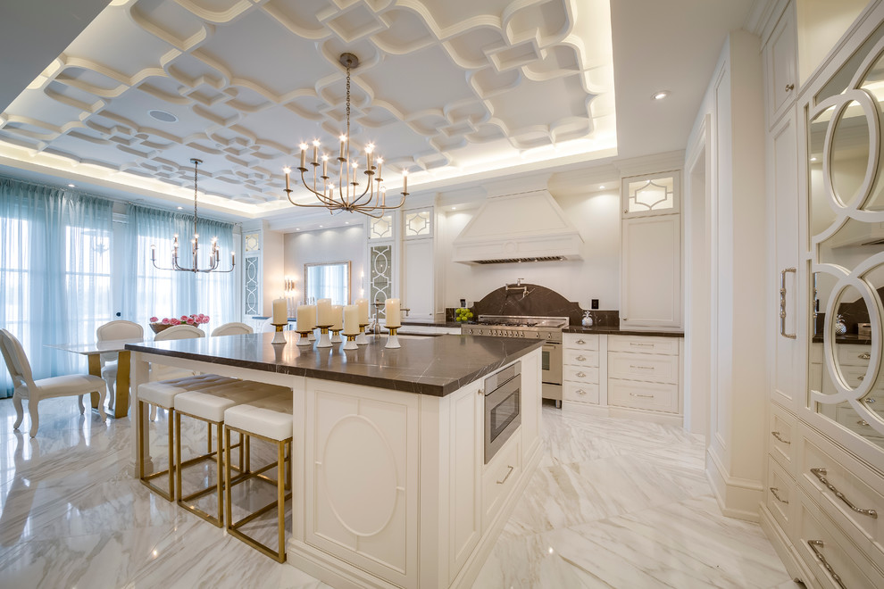 Design ideas for a large traditional single-wall enclosed kitchen in Toronto with a double-bowl sink, raised-panel cabinets, white cabinets, marble worktops, black splashback, stone slab splashback, integrated appliances, marble flooring and an island.