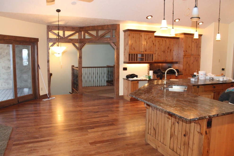 Immagine di una cucina stile rurale di medie dimensioni con lavello a doppia vasca, ante in legno scuro, top in granito, paraspruzzi beige, paraspruzzi con piastrelle a mosaico, elettrodomestici neri, ante in stile shaker e parquet scuro
