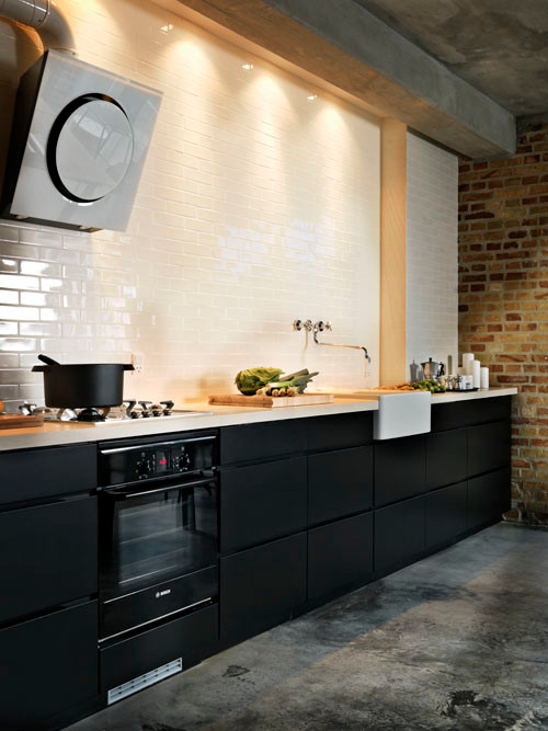Bild på ett mellanstort industriellt linjärt kök och matrum, med en nedsänkt diskho, luckor med lamellpanel, svarta skåp, bänkskiva i kvartsit, vitt stänkskydd, stänkskydd i keramik, vita vitvaror och betonggolv