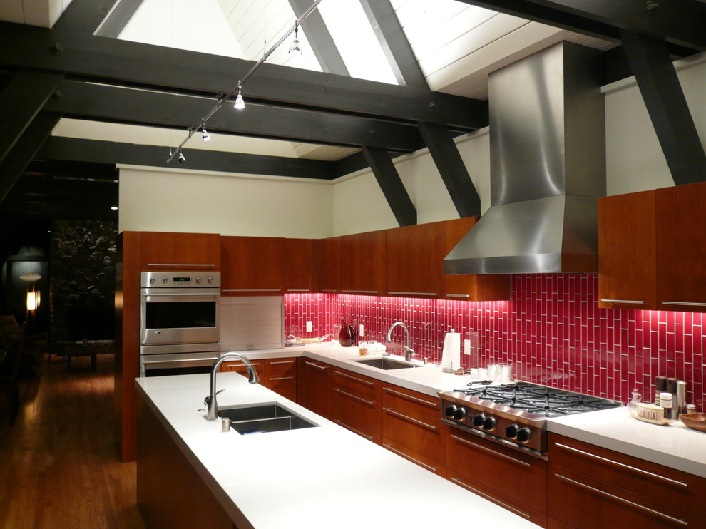 Пример оригинального дизайна: параллельная кухня в стиле ретро с фартуком из керамической плитки, техникой из нержавеющей стали, врезной мойкой, плоскими фасадами, темными деревянными фасадами и красным фартуком