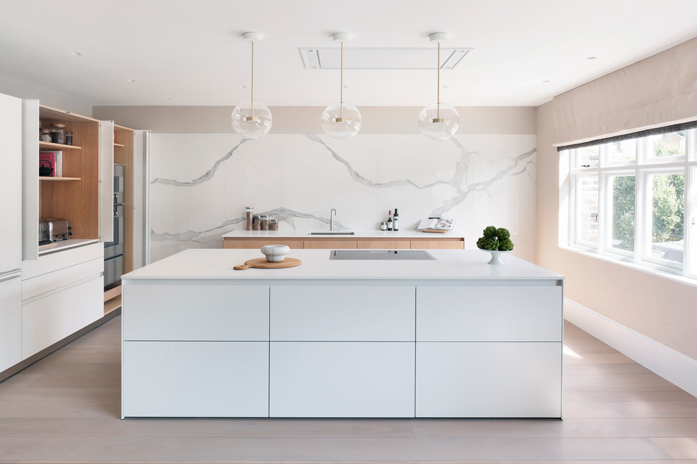 Idéer för ett minimalistiskt vit kök, med en enkel diskho, släta luckor, vita skåp, vitt stänkskydd, stänkskydd i marmor, ljust trägolv, en köksö och beiget golv