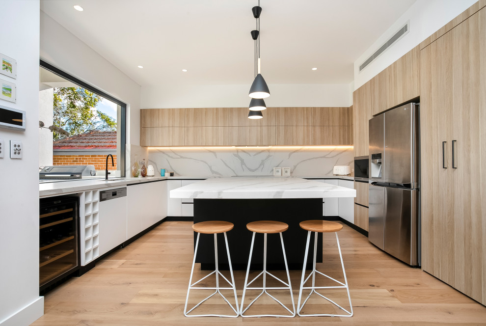 Inspiration for a medium sized contemporary u-shaped kitchen in Sydney with a submerged sink, light wood cabinets, marble worktops, stone slab splashback, stainless steel appliances, medium hardwood flooring and an island.