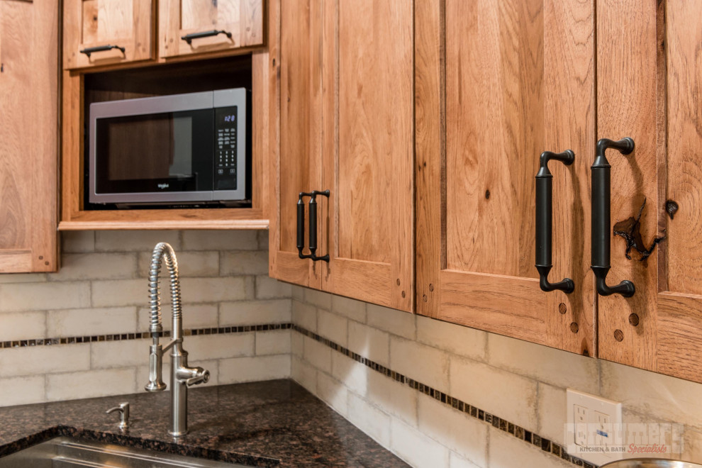 Foto på ett mellanstort rustikt brun kök, med en rustik diskho, skåp i shakerstil, skåp i mellenmörkt trä, granitbänkskiva, vitt stänkskydd, rostfria vitvaror, en köksö och grått golv