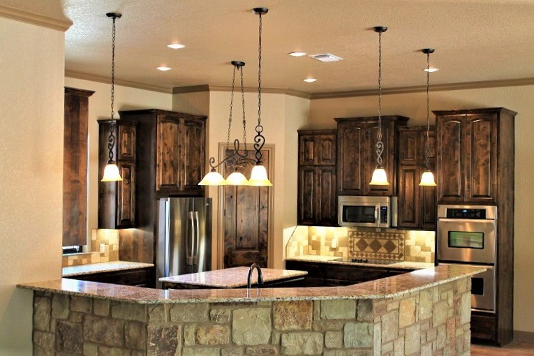 This is an example of a large traditional u-shaped kitchen/diner with a submerged sink, raised-panel cabinets, dark wood cabinets, granite worktops, multi-coloured splashback, stone tiled splashback, stainless steel appliances, an island and multicoloured worktops.