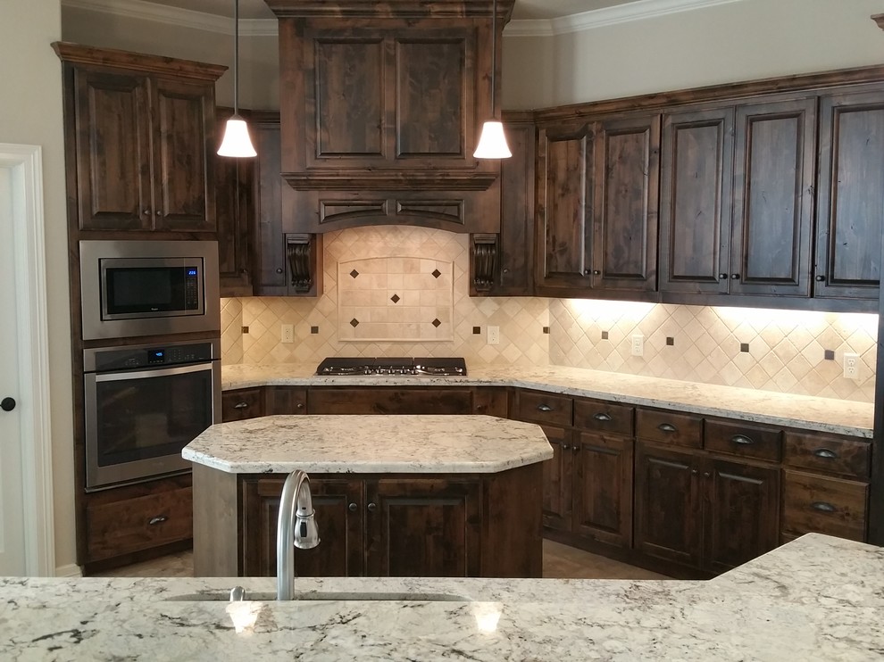 Example of a tuscan kitchen design in Austin with raised-panel cabinets, dark wood cabinets, granite countertops, white backsplash, stone tile backsplash, stainless steel appliances and two islands