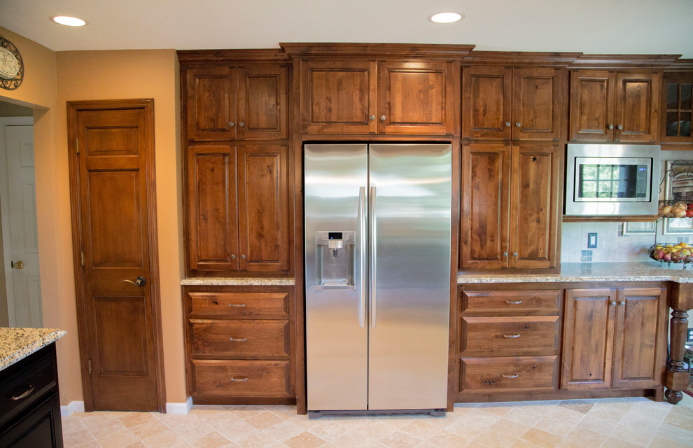 Exempel på ett mellanstort klassiskt kök och matrum, med en undermonterad diskho, luckor med upphöjd panel, skåp i slitet trä, granitbänkskiva, beige stänkskydd, stänkskydd i stenkakel, rostfria vitvaror och travertin golv