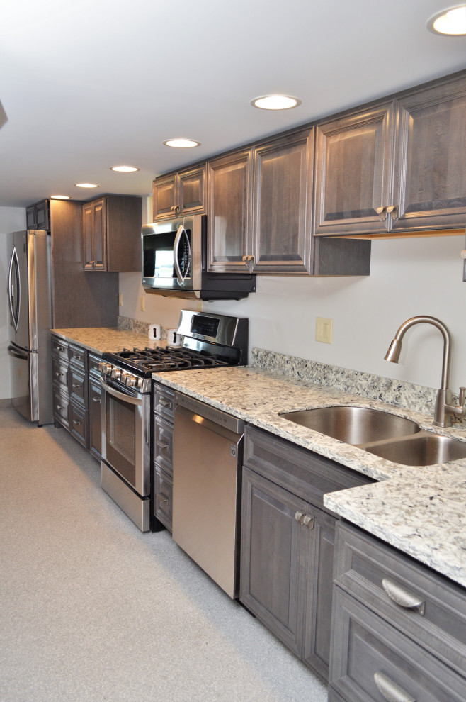 Inredning av ett lantligt avskilt, litet flerfärgad linjärt flerfärgat kök, med en undermonterad diskho, luckor med upphöjd panel, grå skåp, bänkskiva i kvartsit, rostfria vitvaror, laminatgolv och grått golv