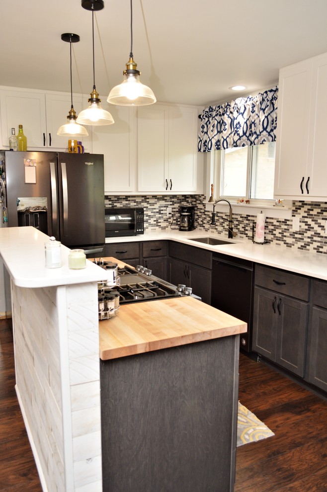 Foto på ett mellanstort lantligt vit kök, med en undermonterad diskho, skåp i shakerstil, grå skåp, bänkskiva i kvartsit, flerfärgad stänkskydd, svarta vitvaror, mörkt trägolv, en köksö och brunt golv