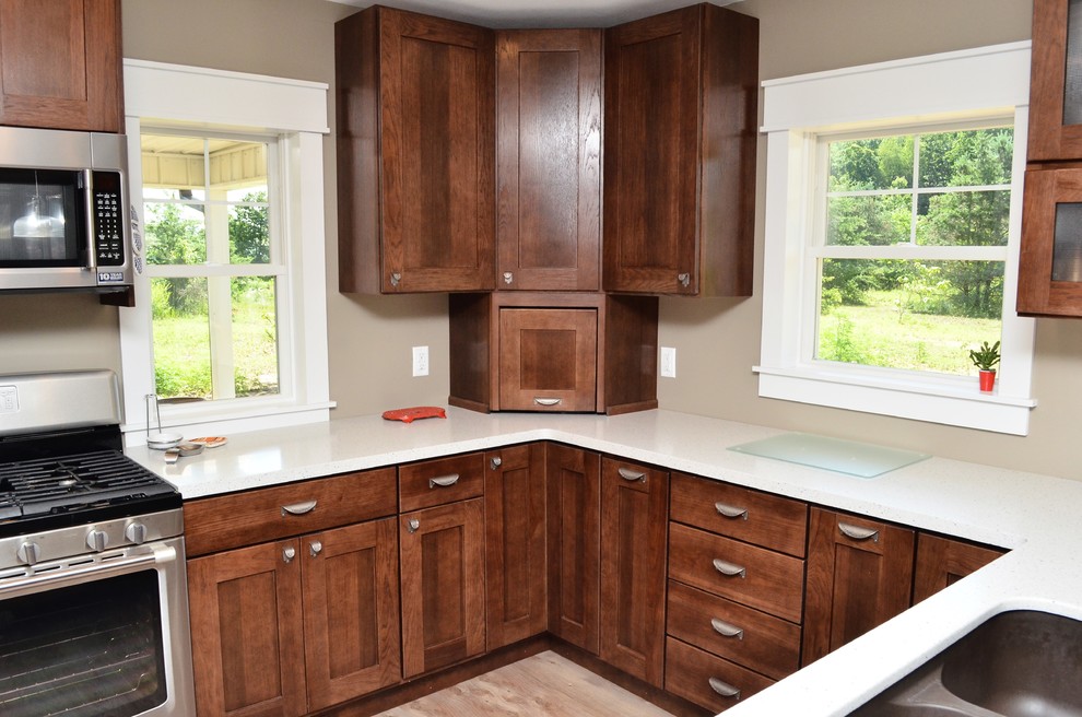 Design ideas for a medium sized traditional u-shaped kitchen/diner in Other with a submerged sink, shaker cabinets, dark wood cabinets, composite countertops, stainless steel appliances, a breakfast bar and white worktops.