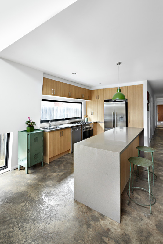 Foto di una piccola cucina design con lavello a doppia vasca, ante lisce, ante in legno scuro, top in superficie solida, paraspruzzi bianco, elettrodomestici in acciaio inossidabile e pavimento in cemento