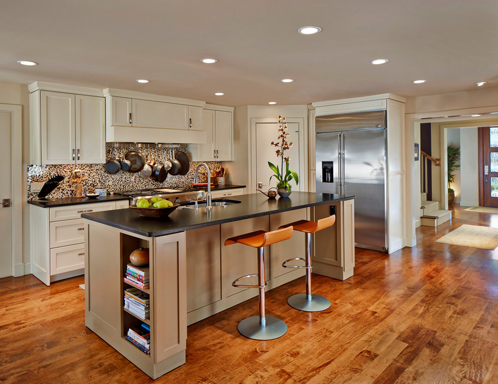 Photo of a traditional l-shaped kitchen in Dallas with a submerged sink, shaker cabinets, beige cabinets, multi-coloured splashback and stainless steel appliances.