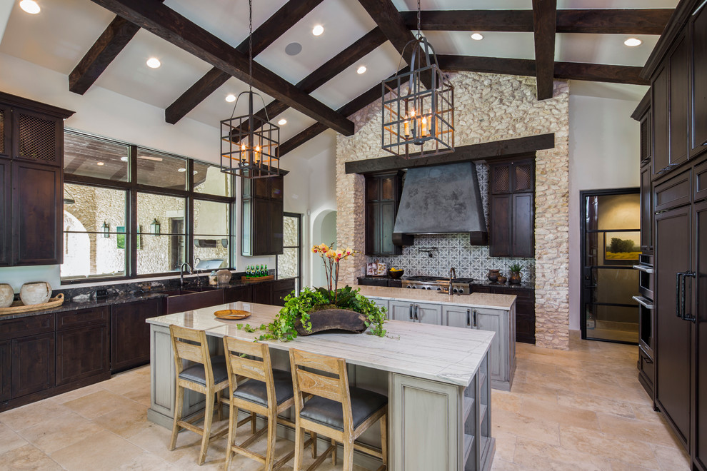 Example of a tuscan u-shaped kitchen design in Austin with two islands, a farmhouse sink, shaker cabinets, dark wood cabinets and multicolored backsplash