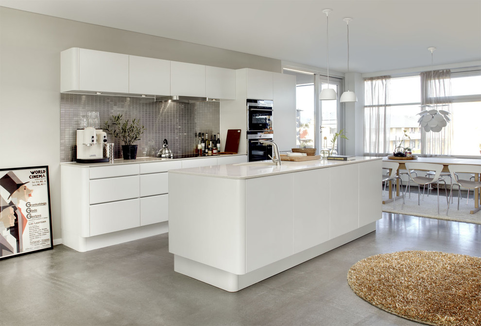 Foto di una cucina minimalista con ante lisce, ante bianche e paraspruzzi grigio