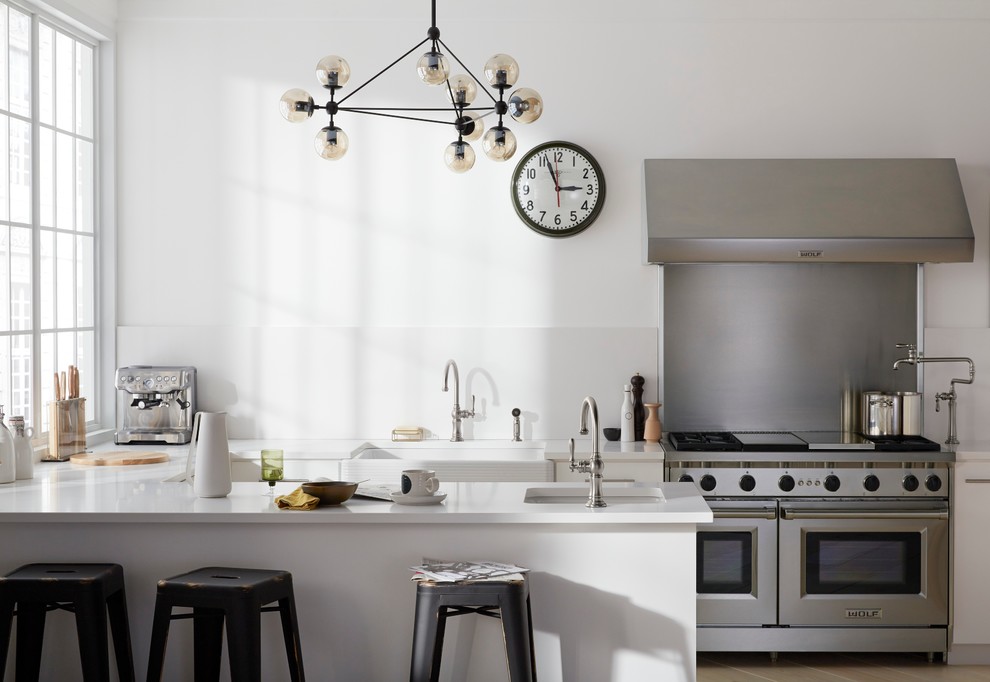 Moderne Wohnküche in L-Form mit Landhausspüle, Schrankfronten mit vertiefter Füllung, weißen Schränken, Mineralwerkstoff-Arbeitsplatte, Küchenrückwand in Weiß, Rückwand aus Keramikfliesen und Kücheninsel in Vancouver