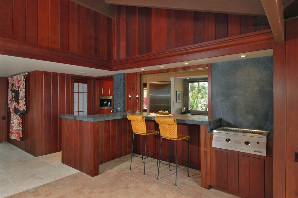Example of an island style kitchen design in Hawaii with stainless steel appliances